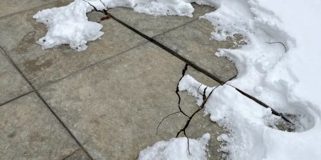 A detailed view of high-quality stone pavers in a winter setting, demonstrating OGS Landscapes’ expertise in choosing materials that withstand freeze-thaw cycles and heavy snow.